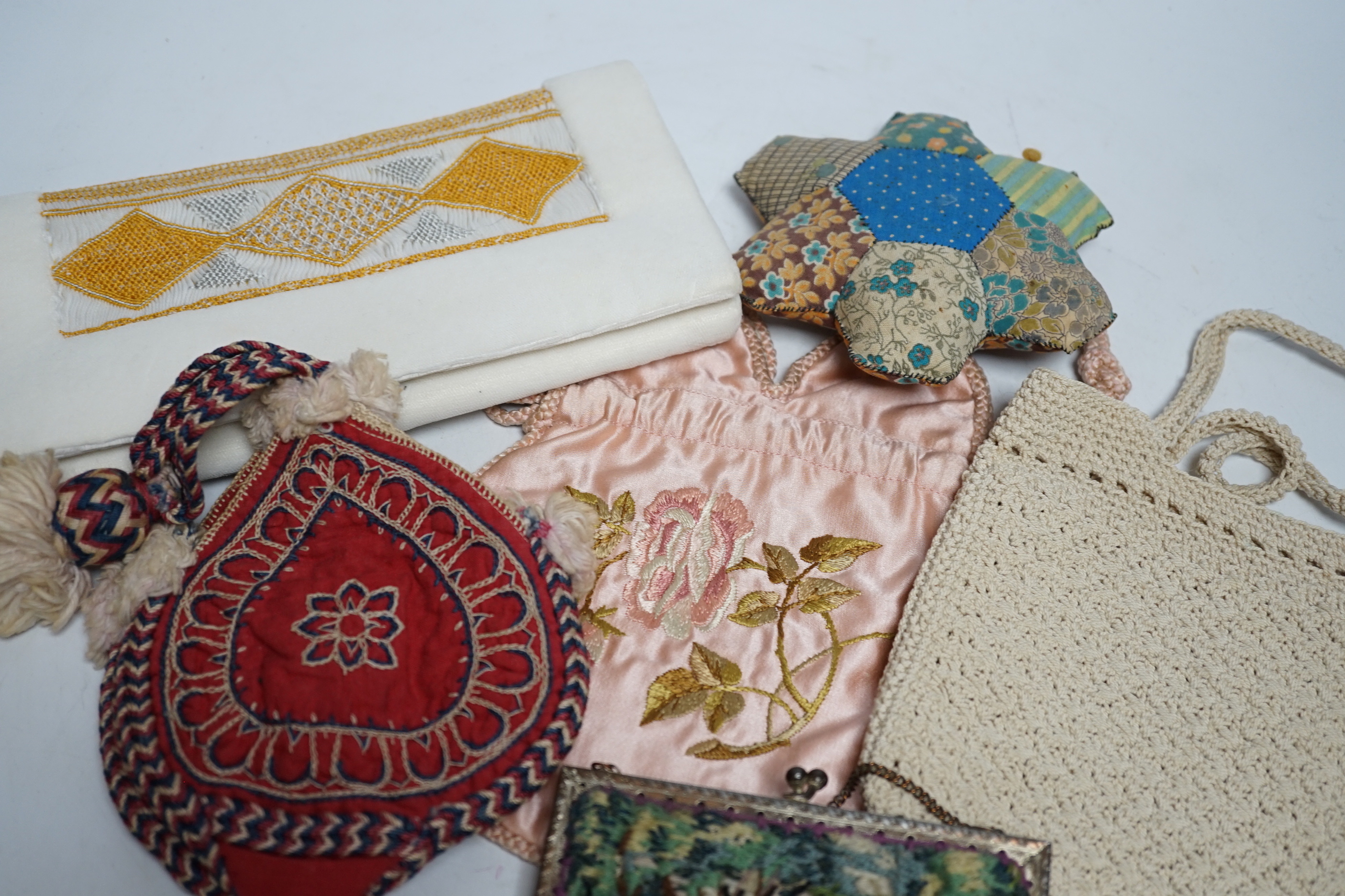 A collection of 20th century embroidered bags, a patchwork pin cushion, a beadwork mat, etc.